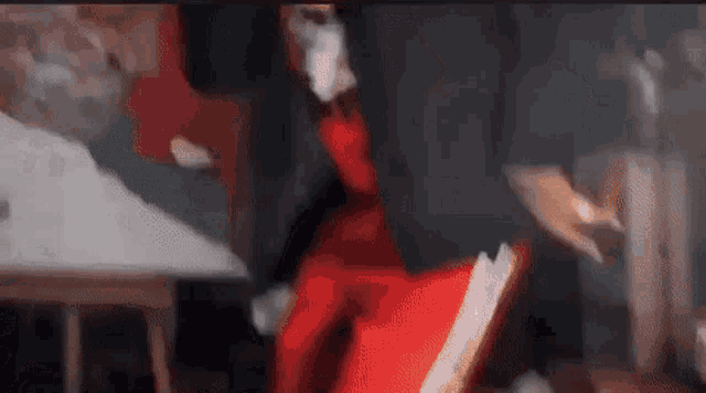 a man in a suit and red pants is dancing in a dark room .