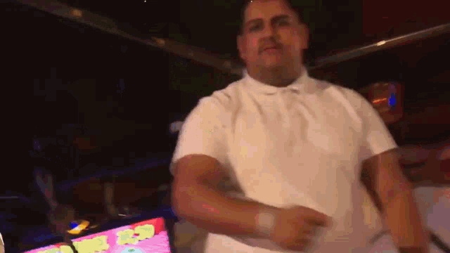 a man in a white shirt is dancing in a room