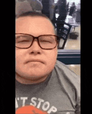 a man wearing glasses and a shirt that says " i 't stop "