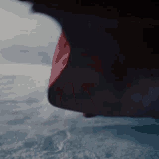 a close up of a person 's face with a red cape