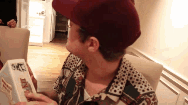 a man wearing a hat is holding a box that says ' diary ' on it