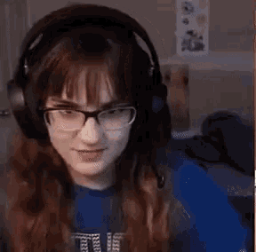 a woman wearing headphones and glasses is sitting in front of a computer .