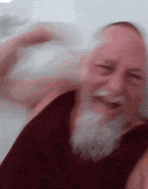 a man with a beard is laying on a bed with his eyes closed