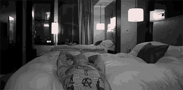 a person is laying on a bed in a hotel room with their feet up .