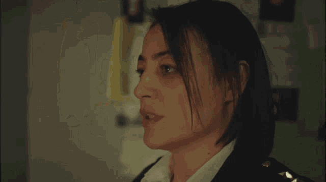 a close up of a woman 's face with a black jacket and white shirt