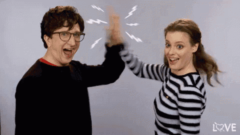 a man and a woman giving each other a high five