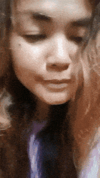 a close up of a woman 's face with her eyes closed and her hair blowing in the wind