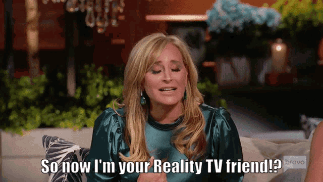 a woman sitting on a couch says so now i 'm your reality tv friend bravo