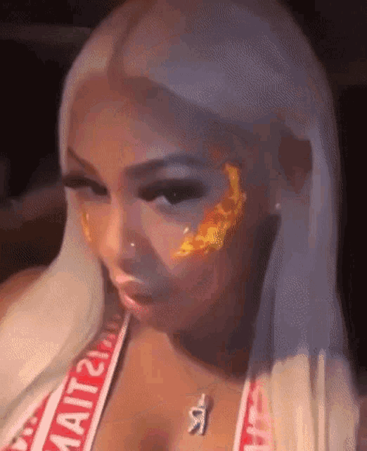 a close up of a woman 's face with a flame on her face .