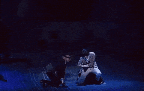a couple of men are dancing on a stage .