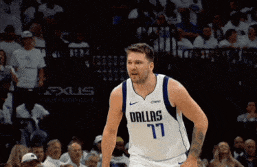 a basketball player wearing a dallas 17 jersey stands on the court