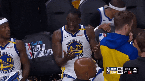 a golden state warriors player talks to a fan