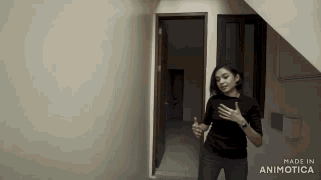 a woman standing in a hallway with the words made in animatica on the bottom right