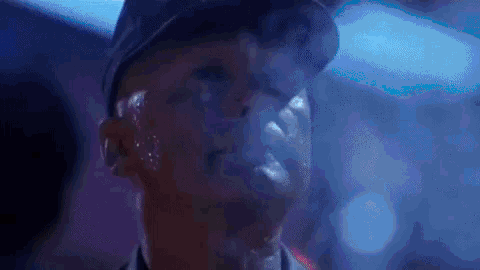 a man is smoking a cigarette in a dark room .