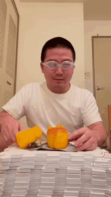 a man wearing glasses is cutting a yellow pepper