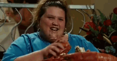 a woman is sitting at a table eating a lobster .