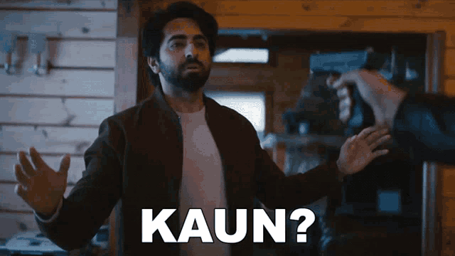 a man with his arms outstretched is being threatened by another man with a gun and the caption kaun