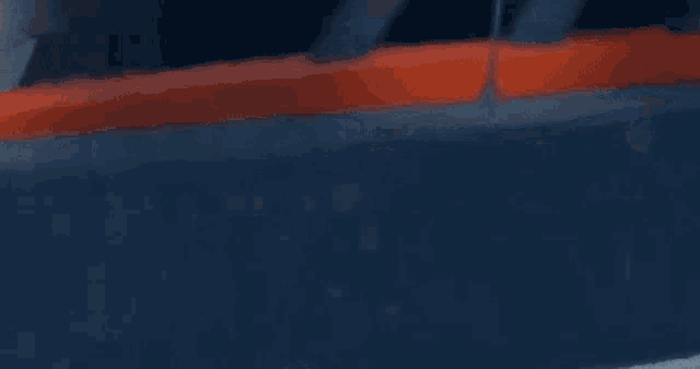a blurred image of a car driving down a road at night with a street light in the background .