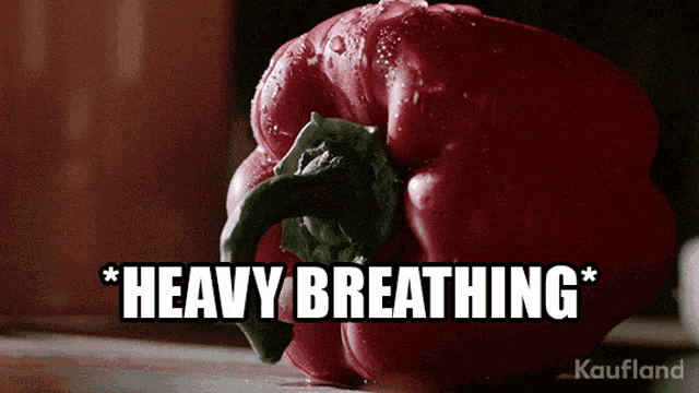 a red pepper is sitting on a cutting board with the caption " heavy breathing "