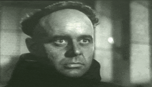 a man with a bald head looks at the camera