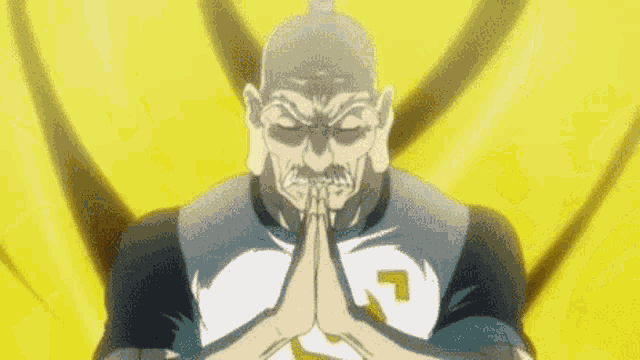 a man with a beard is praying with his hands together in front of a yellow background .