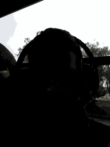 a man wearing headphones looks out of a window