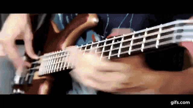 a close up of a person playing a guitar with a gifs.com watermark
