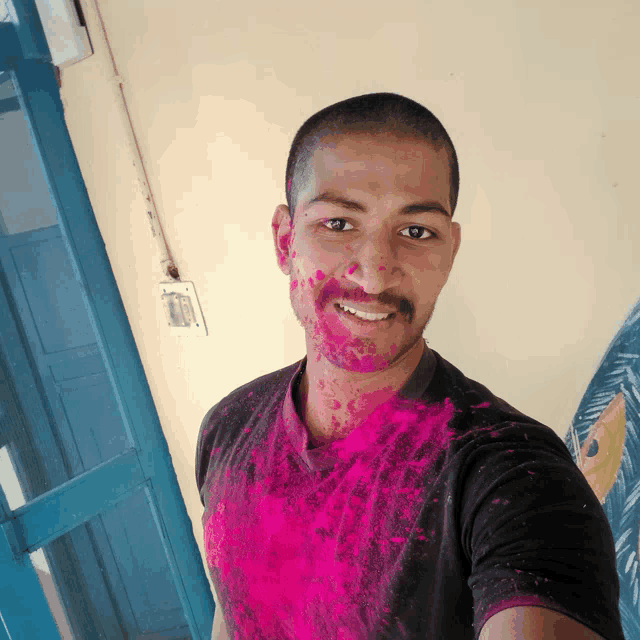 a man is covered in pink powder and smiling