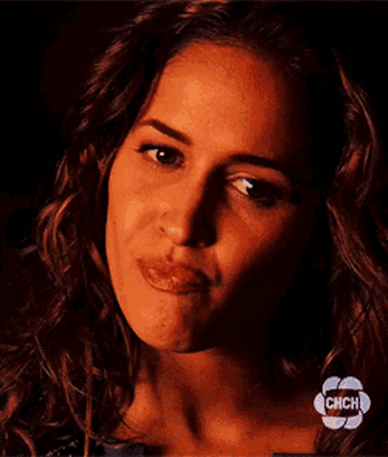 a close up of a woman 's face with chch written on the bottom right