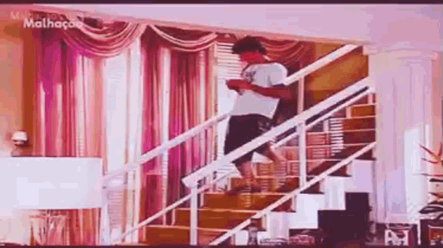 a man is walking down a set of stairs in a living room .