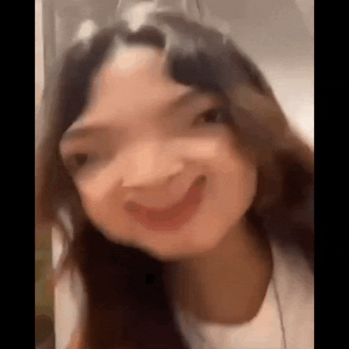 a close up of a woman making a funny face and smiling .
