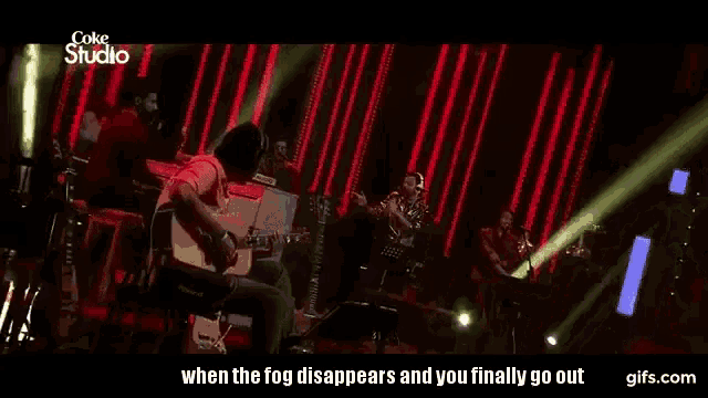 a man is playing a guitar on stage in front of a coke studio logo