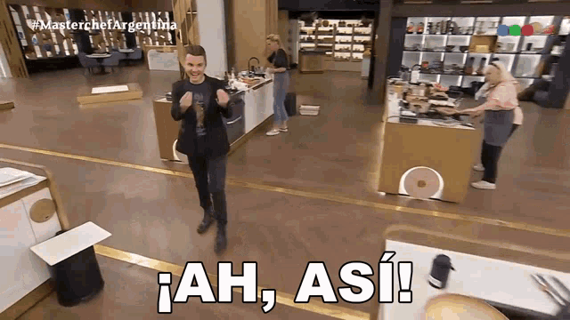 a man in a suit stands in a kitchen with the words ah , asi written on the floor