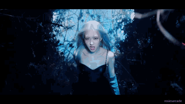 a close up of a woman with blue hair making a face .
