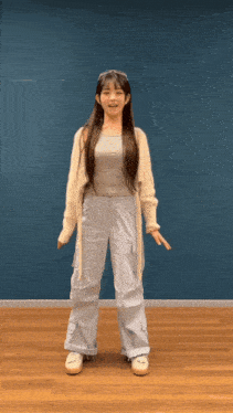 a girl with long hair is standing in front of a blue background