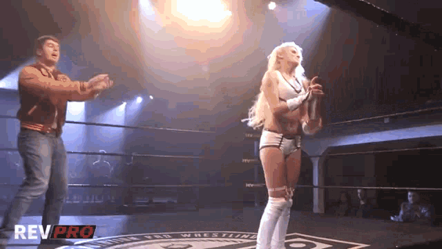 a woman in a wrestling ring with rev pro on the bottom right