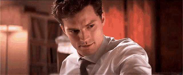 a man in a white shirt and tie looks at the camera .