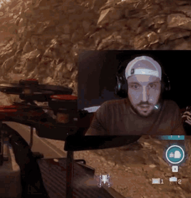 a man wearing headphones and a baseball cap is playing a game