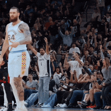 a basketball player wearing the number 54 stands in front of a crowd