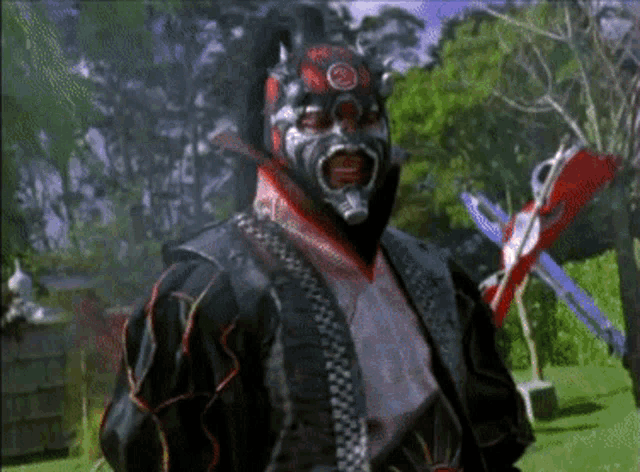 a man wearing a mask and holding a sword is standing in a park