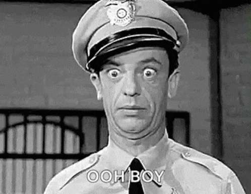 a black and white photo of a police officer making a funny face and saying ooh boy .
