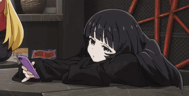 a girl is laying on the floor looking at her phone with a box of snow candy in the background