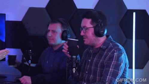two men wearing headphones are sitting in front of a microphone with gifrun.com in the corner