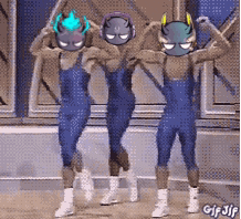a gif of three people dancing with devil masks on their faces .