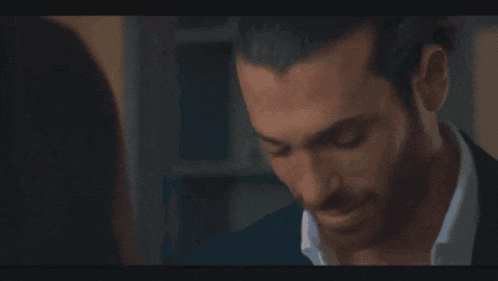 a close up of a man 's face with a woman behind him