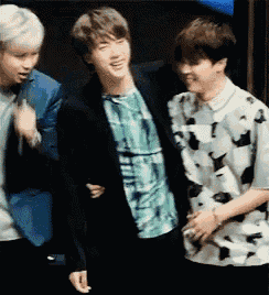 a group of young men are standing next to each other and one of them is wearing a plaid shirt .