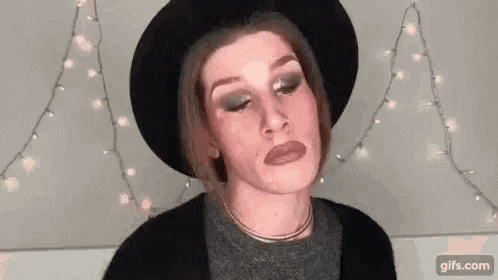 a woman is wearing a hat and making a funny face .