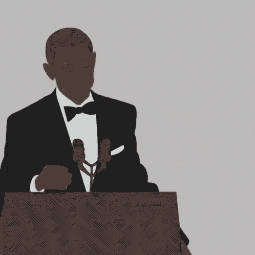 a man in a suit is holding a microphone in front of his mouth