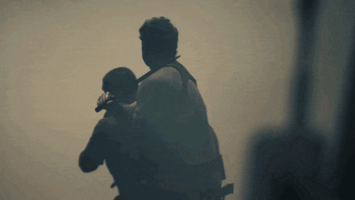 a man is carrying another man on his back in the dark