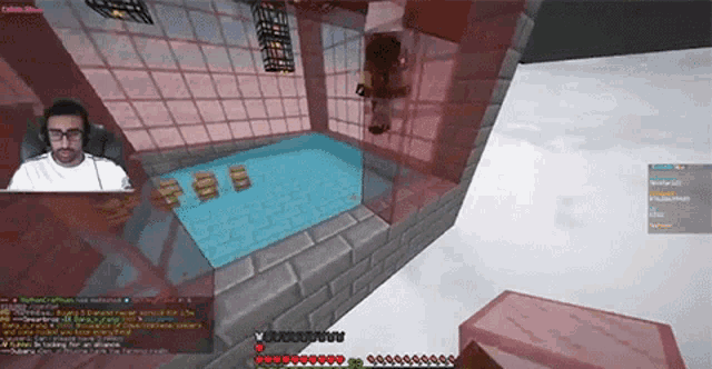 a man is playing a video game in front of a pool of water .